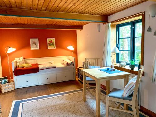 a room with a bed and a desk and a table at Reetdachkate Müllerhaus von 1860 in Thalingburen