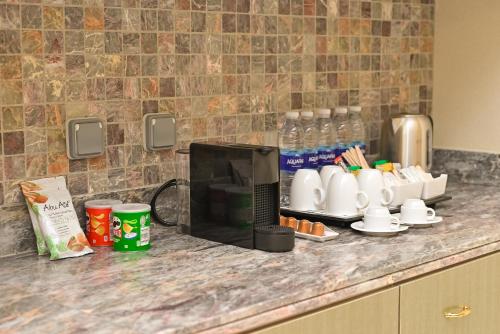 a counter with a coffee maker and cups on it at Hilton Hurghada Plaza Hotel in Hurghada