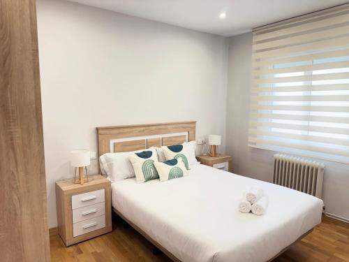 a bedroom with a large white bed with pillows at Rioja centro Ayuntamiento by Apartamentos Logrono in Logroño