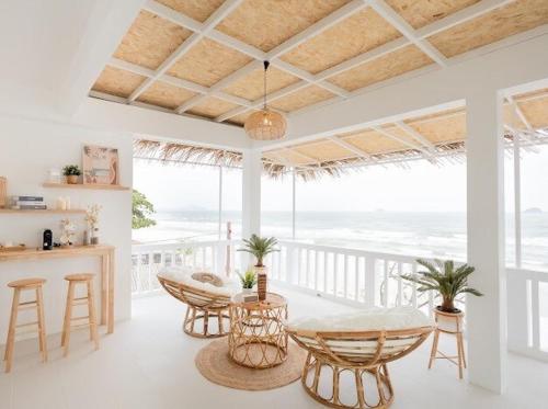 a living room with a table and chairs and the ocean at Stories Stay pool villa Huahin พูลวิลล่าหัวหิน ติดทะเล in Sathani Khao Tao