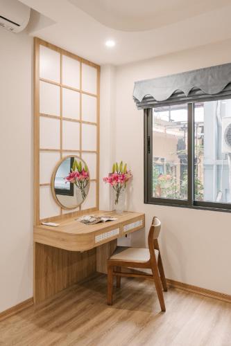 a desk with a mirror and a chair in a room at Lux Japan Town Studio in Hanoi