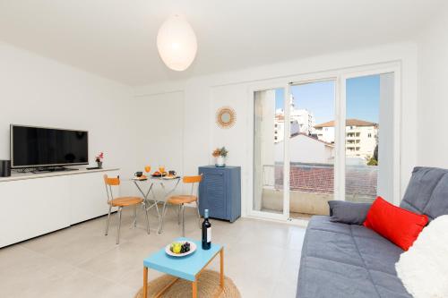 un salon avec un canapé et une table dans l'établissement Le Lido YourHostHelper, à Cannes