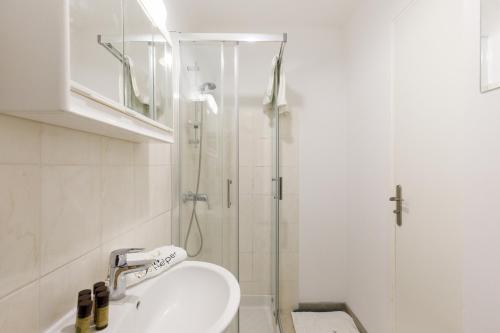 une salle de bain avec un lavabo et une douche dans l'établissement Le Lido YourHostHelper, à Cannes