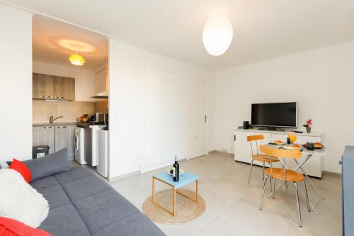 un salon avec un canapé et une table dans l'établissement Le Lido YourHostHelper, à Cannes