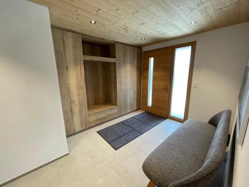 a living room with a chair and a door at Bergblick Apartments - Weisshorn in Brienz