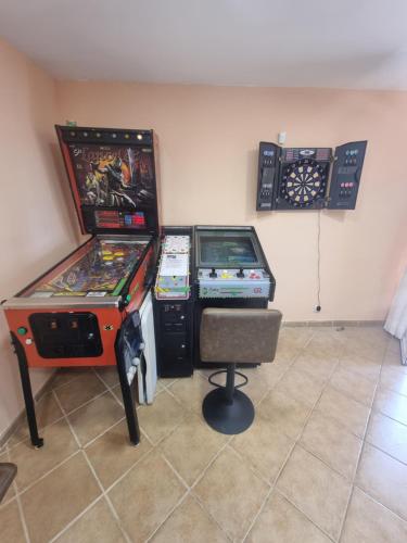 two arcade games and a chair in a room at VUT EL Mogollón in Guadalajara