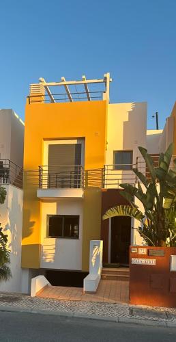 a yellow building with a balcony on the side of it at Casa Kiki in Ferragudo