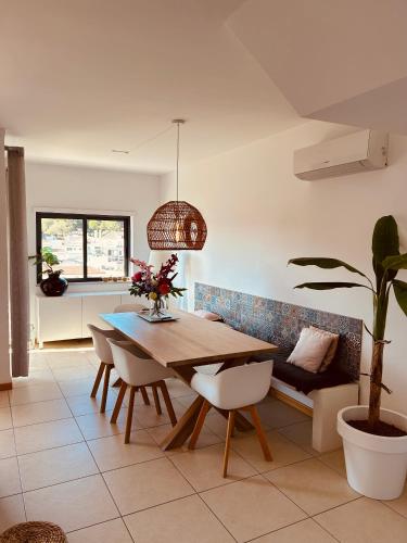 a dining room with a table and a potted plant at Casa Kiki in Ferragudo