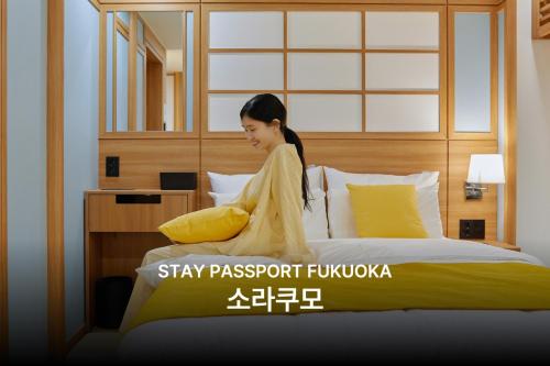 a woman sitting on top of a bed at 스테이 패스포트 후쿠오카 료칸 대전 유성점 in Daejeon