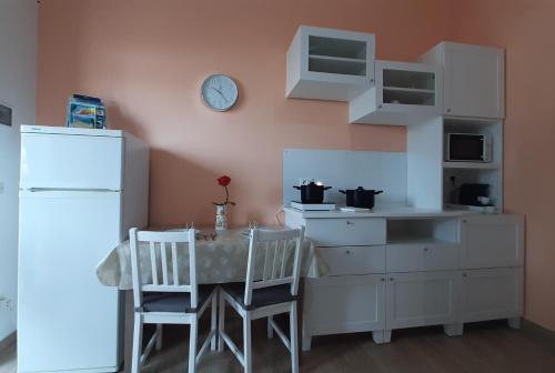 a kitchen with a table and chairs and a clock on the wall at Casa Roberto in Campomarino