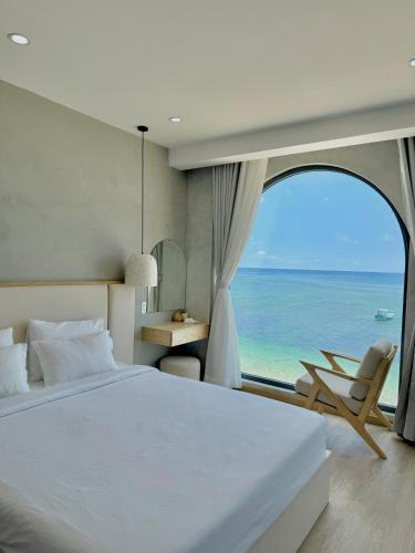 a bedroom with a bed and a view of the ocean at La Mer Boutique House in Cù Lao Thu