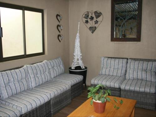 a living room with two couches and a table at La Belle Guesthouse Parys in Parys