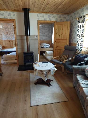 a living room with a table and a stove at The cabin by the river in Särna