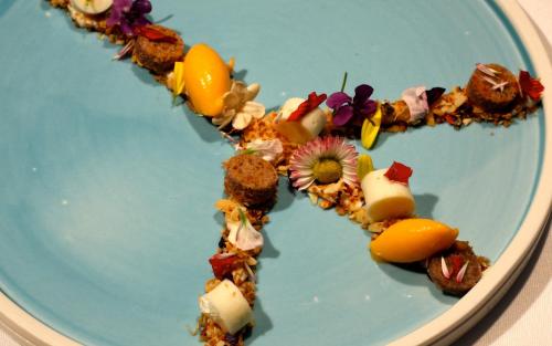 a blue plate with food in the shape of a heart at Hotel Vier Jahreszeiten Binz in Binz