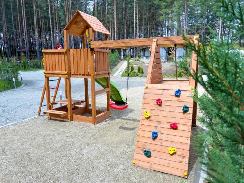 a wooden playground with a slide and a play structure at Къмпинг Alino Lake in Alino