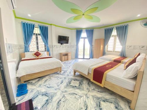 two beds in a room with a flower painted on the ceiling at Ngọc Quý 2 Hotel Phan Rang in Phan Rang