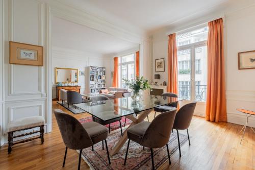 une salle à manger avec une table et des chaises en verre dans l'établissement Veeve - Peachy Butterflies, à Paris