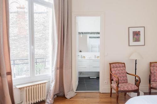 - une chambre avec un miroir, une chaise et un lavabo dans l'établissement Veeve - Peachy Butterflies, à Paris