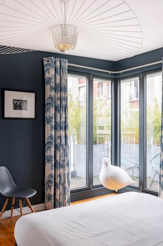 une chambre avec un lit et une grande fenêtre dans l'établissement Veeve - Seagull’s House, à Boulogne-Billancourt
