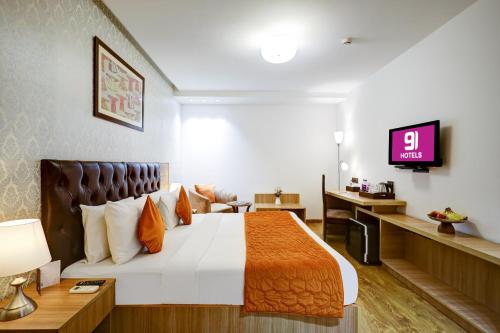 a hotel room with a bed and a tv at Hotel 91 Huda City Centre in Gurgaon