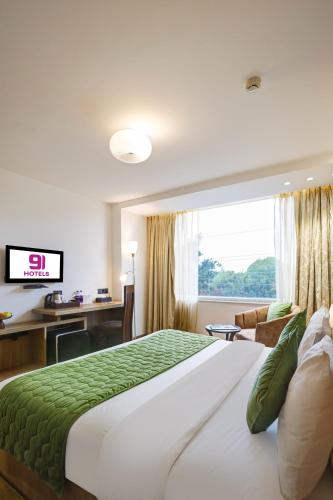 a hotel room with a large bed and a window at Hotel 91 Huda City Centre in Gurgaon