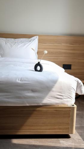 a bedroom with a bed with a wooden headboard at Akoya Business Hotel Hyderabad Airpot in Shamshabad