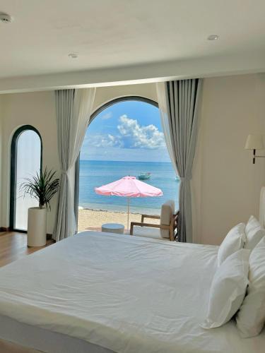 a bedroom with a bed and an ocean view at La Mer Boutique House in Cù Lao Thu