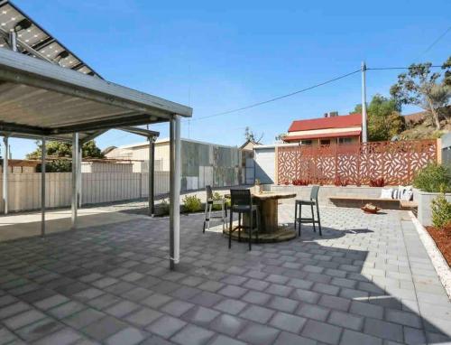 a patio with a table and chairs under a pavilion at Tillys Townhouse in Broken Hill