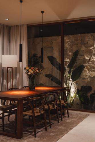 a wooden table with a vase of flowers on top at Sore Escape Tumbak Bayuh by Betterplace in Tumbak Bayuh