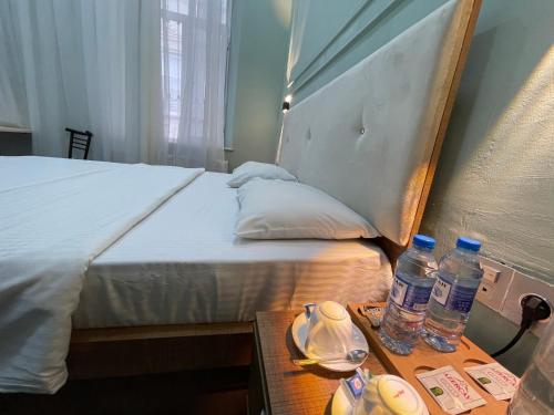 a bed with two bottles of water on a table at RUNO inn Hotel in Baku