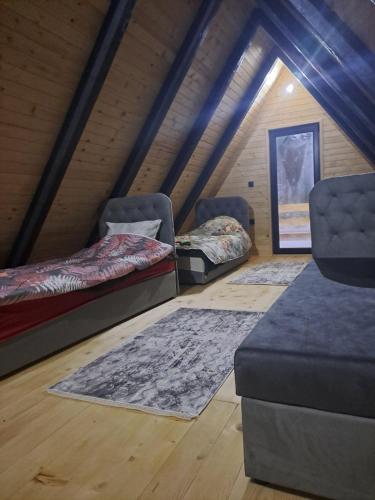 a room with two beds and rugs in a attic at ROMANIJA vikendice in Koprivice