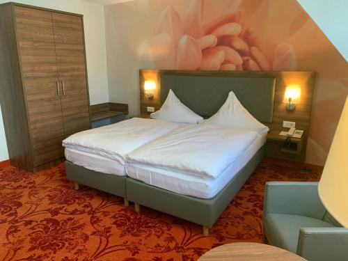 a hotel room with a bed and a chair at Hotel Felsenkeller in Rüdesheim am Rhein