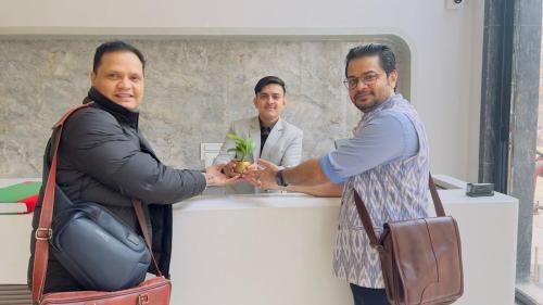 a group of men standing around a counter shaking hands at The Viking Hotel- 5 Minutes away from New Delhi Railway & Connaught Place in New Delhi