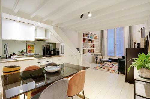 une cuisine avec une table et des chaises dans une pièce dans l'établissement Appartement Montmartre, à Paris