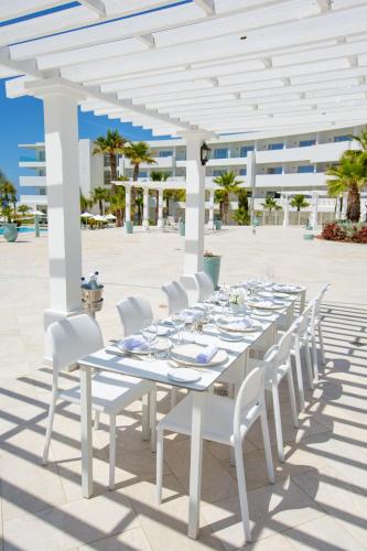 a long white table and chairs on a patio at Lixus Beach Resort - All In in Larache