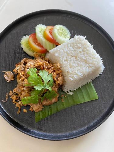 a plate of food with rice and fruit on it at PLAAI Plus Hotel Rayong in Rayong