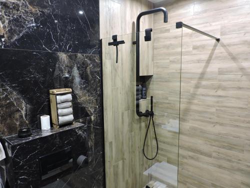 a bathroom with a shower with a glass door at Centro Residence in Kluczbork