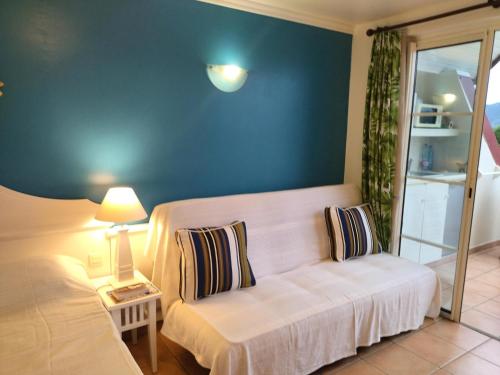 a living room with a white couch and a blue wall at PIERRE & VACANCES Margarita 35 in Sainte-Luce