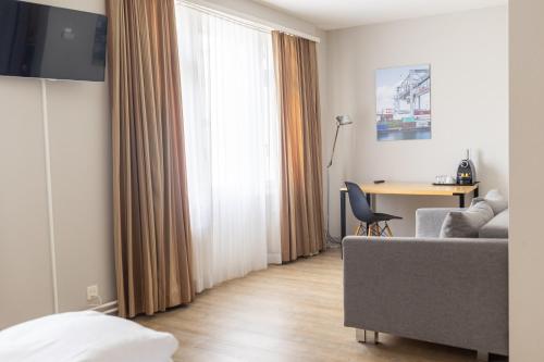 a living room with a couch and a table and a window at Royal Hotel - Urban Living in Basel