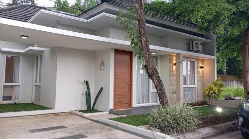 una casa bianca con una porta rossa e una palma di Villa Bougenville Inn a Salakan
