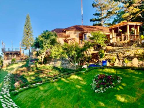 a large house with a yard with a green lawn at Rosa Homestay in Ấp Trạm Hành