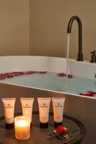 a table with candles and a bath tub with a sink at ARULA J Hotel in Lijiang