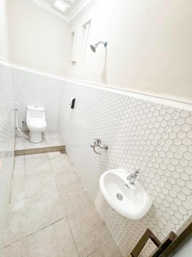 a bathroom with a sink and a toilet at El Rio Alun-Alun Tegal Hotel by Sajiwa in Tegal