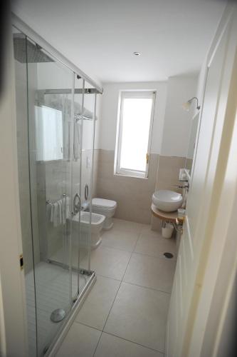 a bathroom with a glass shower and a toilet at Minori Palace in Minori