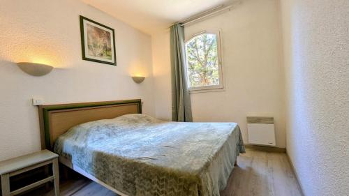 une chambre avec un lit et une fenêtre dans l'établissement Domaine de Valescure Apt 2 chambres, à Saint-Raphaël