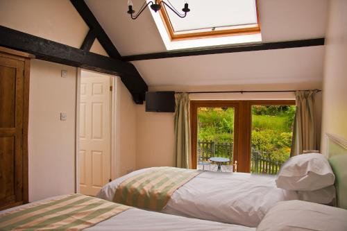 a bedroom with two beds and a window at Ghyll Farm B & B in Lamplugh
