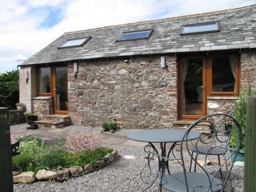 a stone cottage with a table in front of it at Ghyll Farm B & B in Lamplugh