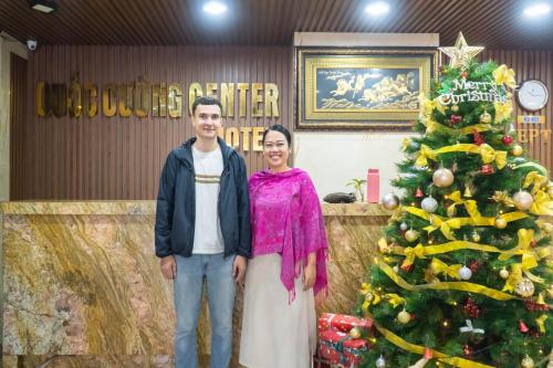 a man and a woman standing next to a christmas tree at Quoc Cuong Center Da Nang Hotel by Haviland in Da Nang