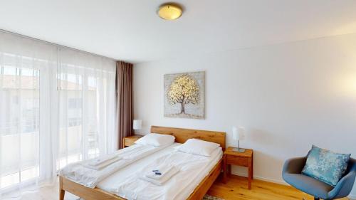 Un dormitorio con una cama, una silla y una ventana en Amazing big studio in the city center - Sun 7, en Zúrich
