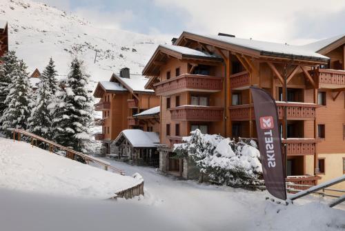 a ski lodge with a sign in the snow at Résidence Pierre & Vacances Premium Les Alpages de Reberty in Les Menuires
